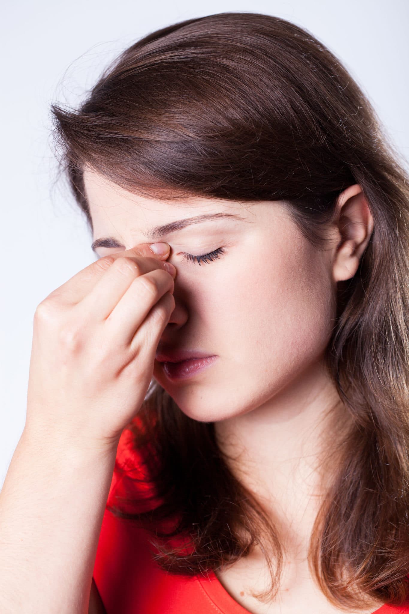a woman pinches her nose
